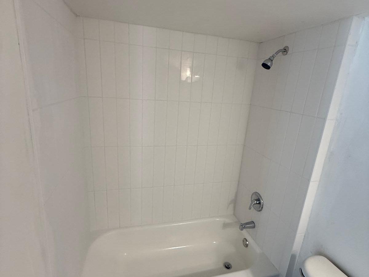 Finished bathroom with new white tile surround and clean drywall