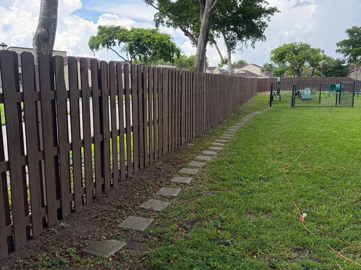 Fence fully restored and stained in a uniform brown finish