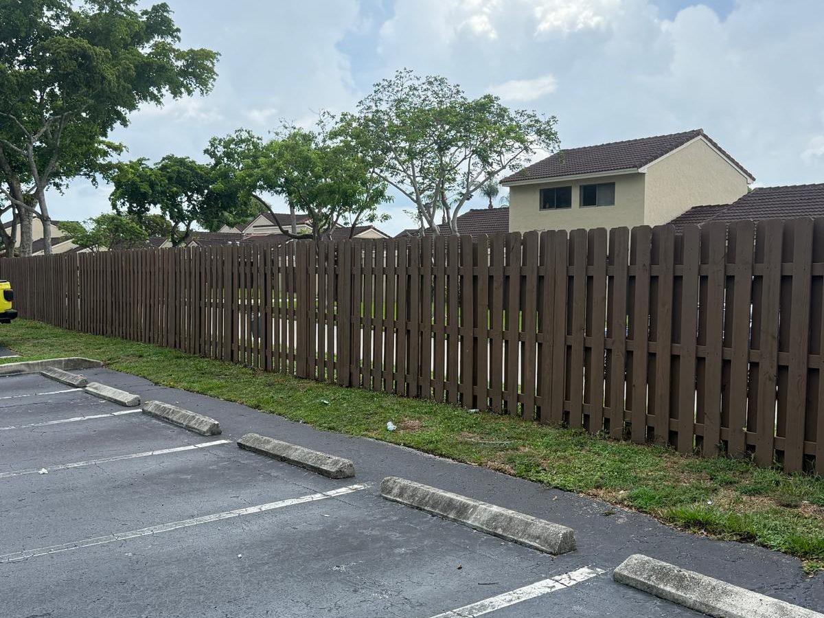 Fence rebuilt with new boards and a clean brown finish